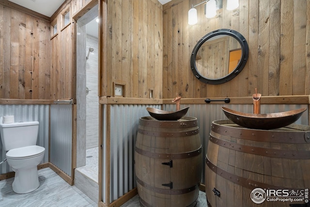 bathroom with wood walls and toilet