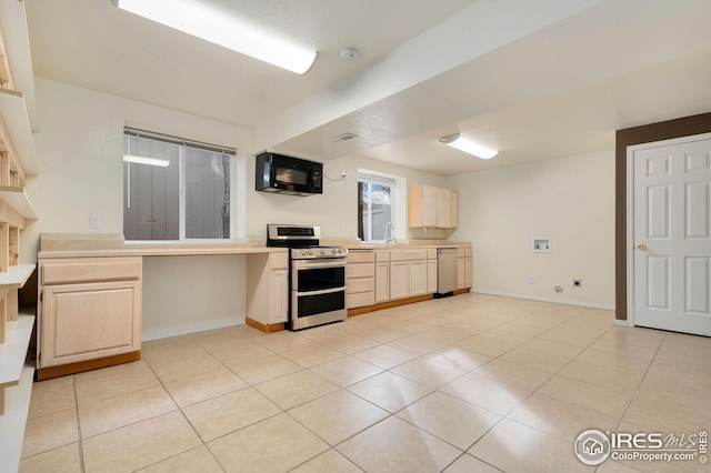 kitchen featuring appliances with stainless steel finishes, sink, light tile patterned floors, and light brown cabinetry