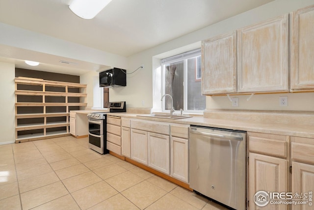 kitchen featuring sink, light tile patterned flooring, light brown cabinets, and appliances with stainless steel finishes