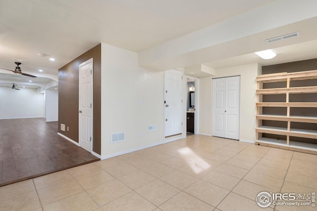 empty room with light tile patterned floors and ceiling fan