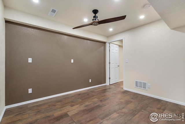 spare room featuring dark hardwood / wood-style flooring and ceiling fan