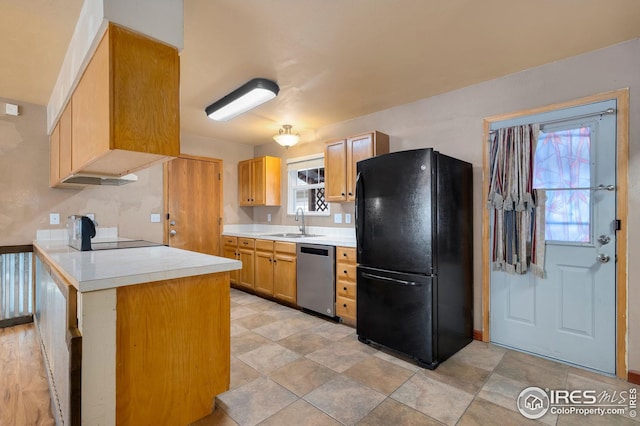 kitchen featuring black fridge, stainless steel dishwasher, plenty of natural light, and sink