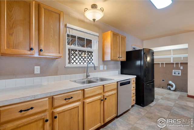 kitchen with black fridge, stainless steel dishwasher, and sink