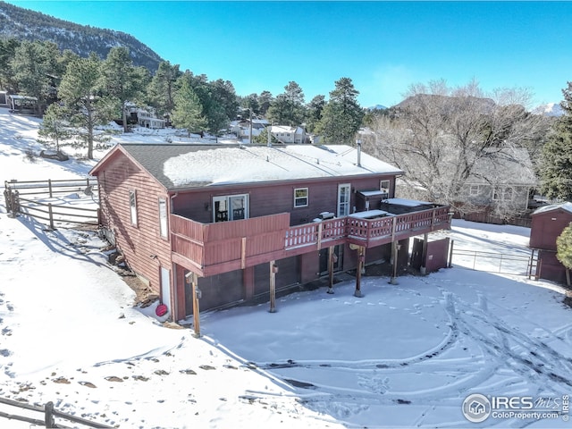 snow covered property featuring a deck with mountain view