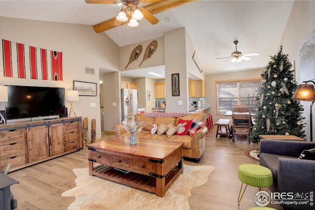 living room with beam ceiling, ceiling fan, high vaulted ceiling, and light hardwood / wood-style floors