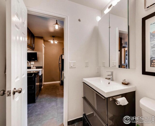 bathroom with tile patterned flooring, vanity, a wall mounted AC, and toilet