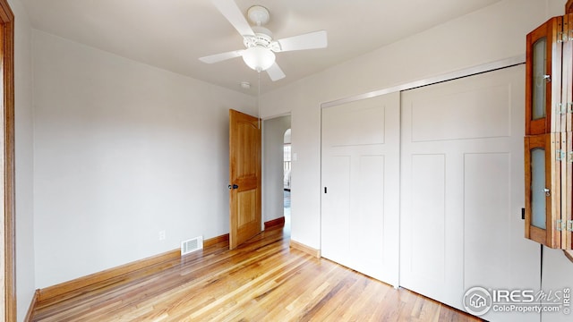 unfurnished bedroom with light hardwood / wood-style flooring, a closet, and ceiling fan