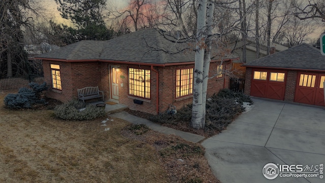 view of front of house featuring a garage, an outbuilding, and a lawn