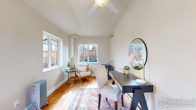 office space featuring ceiling fan, lofted ceiling, radiator, and light hardwood / wood-style floors