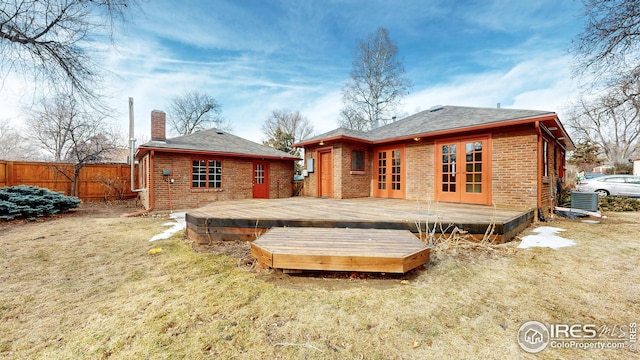 rear view of property featuring a wooden deck, a yard, central AC, and french doors