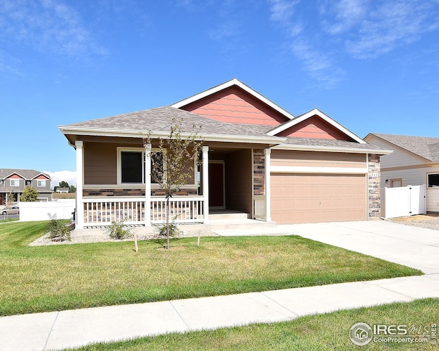 view of front of house with a porch, a garage, and a front lawn