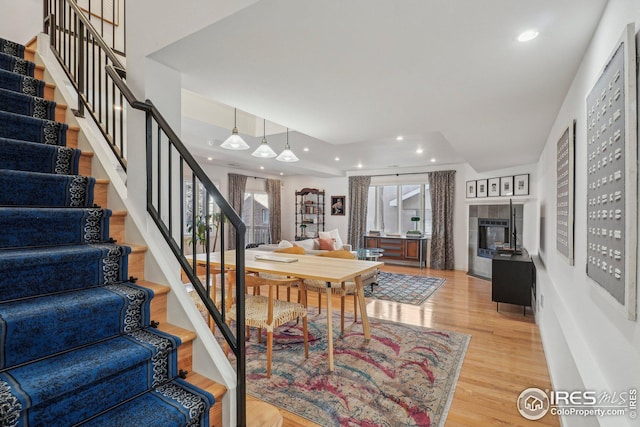 dining space with a tile fireplace and light hardwood / wood-style floors