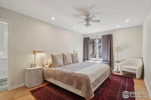 bedroom with ceiling fan, ensuite bathroom, and light hardwood / wood-style floors