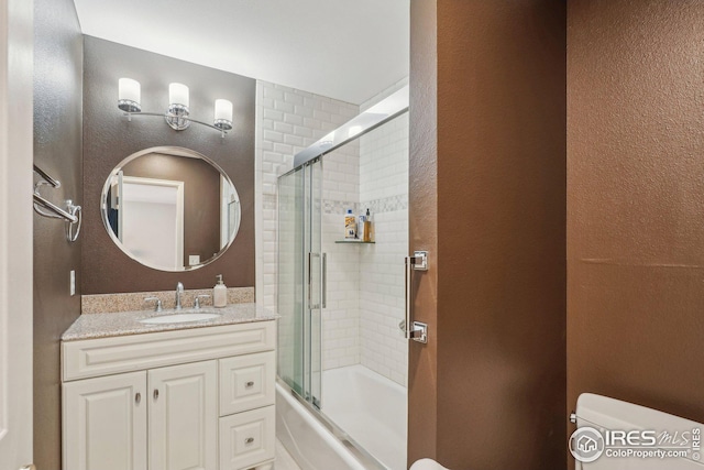 full bathroom featuring bath / shower combo with glass door, vanity, and toilet