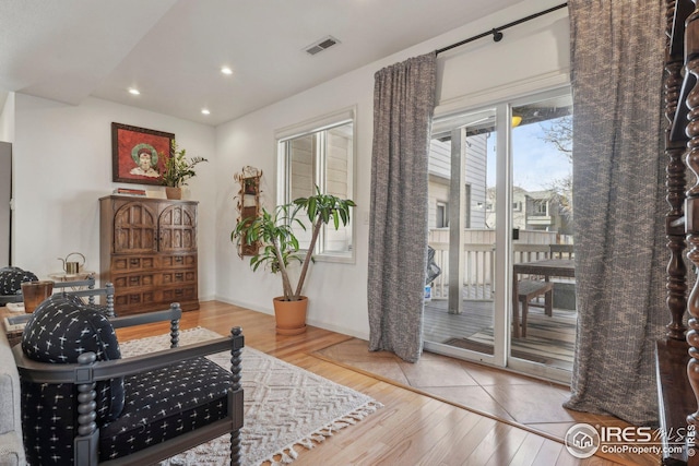 sitting room with hardwood / wood-style flooring and a healthy amount of sunlight