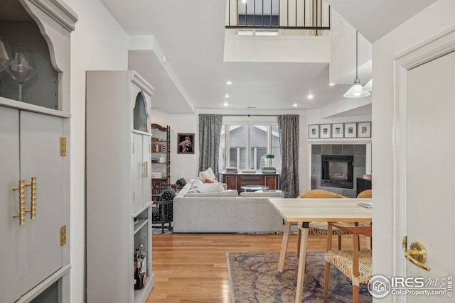 living room with a tiled fireplace and light hardwood / wood-style floors