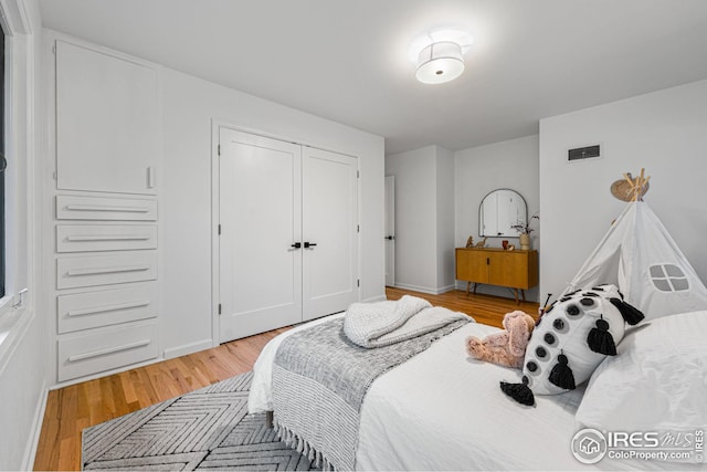 bedroom with a closet and light hardwood / wood-style flooring