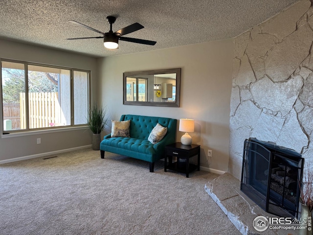 unfurnished living room with ceiling fan, carpet flooring, a textured ceiling, and a fireplace