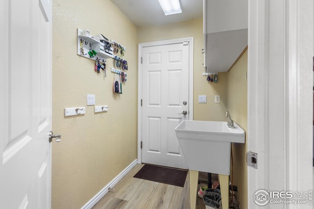 laundry room with light wood-type flooring