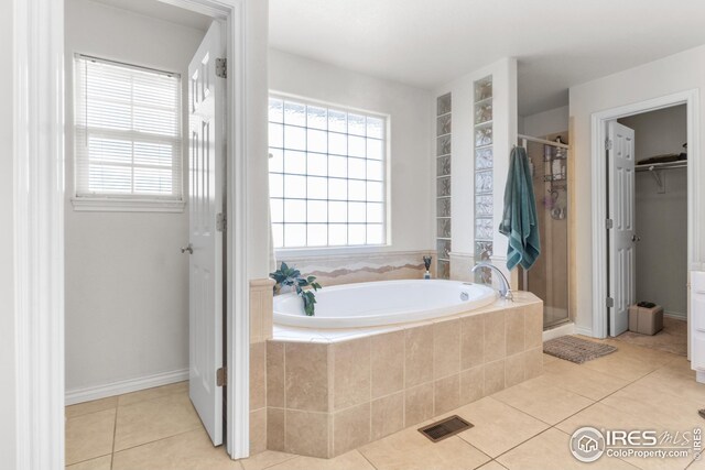 bathroom featuring tile patterned floors and independent shower and bath