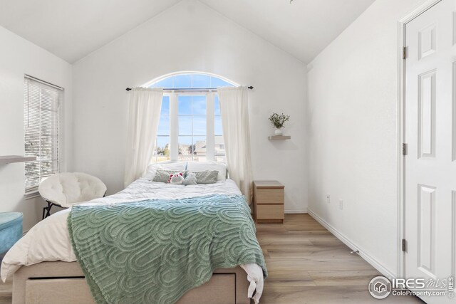 bedroom with vaulted ceiling and light hardwood / wood-style floors