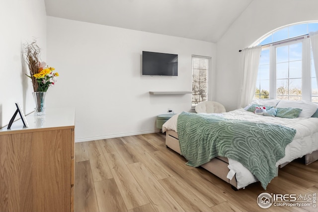 bedroom with light hardwood / wood-style flooring and vaulted ceiling