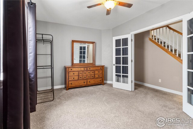 interior space with light colored carpet, ceiling fan, and french doors