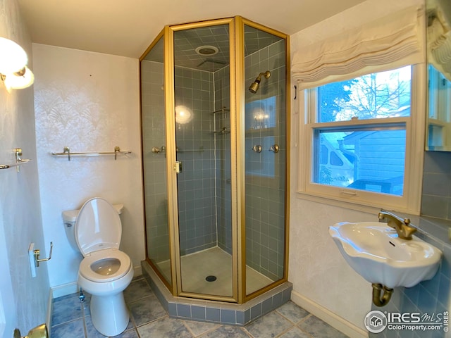 bathroom with an enclosed shower, sink, tile patterned floors, and toilet