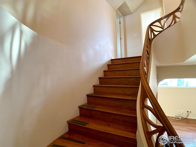 stairway featuring hardwood / wood-style flooring and vaulted ceiling