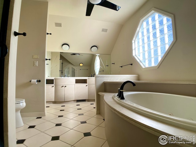 bathroom with vaulted ceiling, a bathing tub, vanity, ceiling fan, and toilet