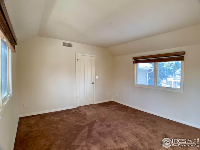 carpeted spare room featuring lofted ceiling