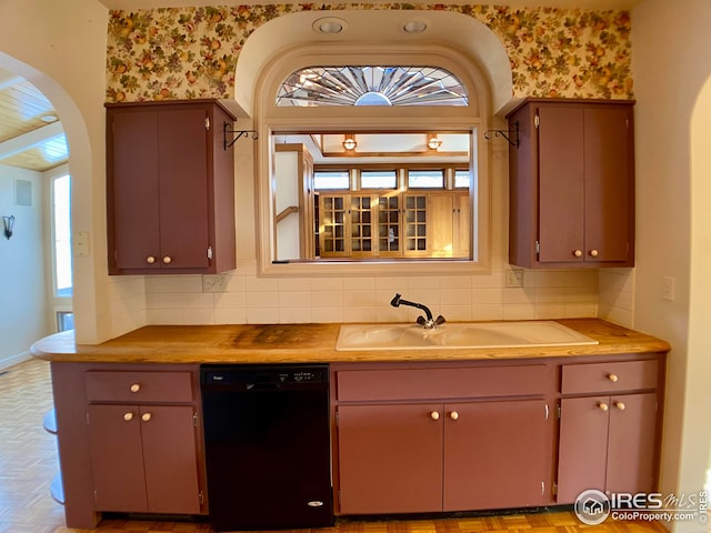 kitchen featuring black dishwasher, sink, light parquet floors, and backsplash