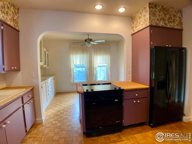 kitchen with light parquet flooring, ceiling fan, and black refrigerator with ice dispenser