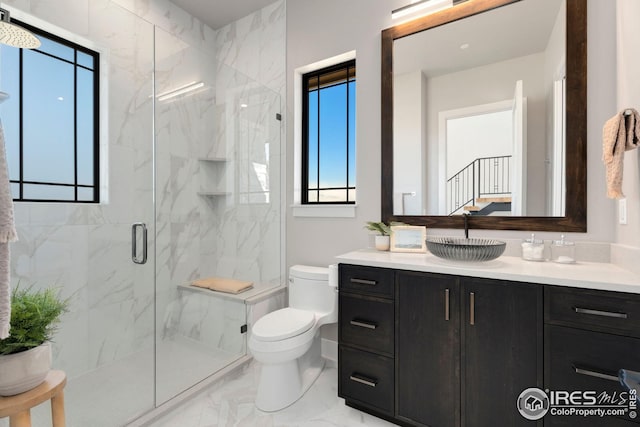 full bath with vanity, toilet, marble finish floor, and a marble finish shower