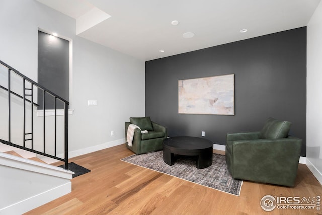 sitting room with stairway, wood finished floors, and baseboards