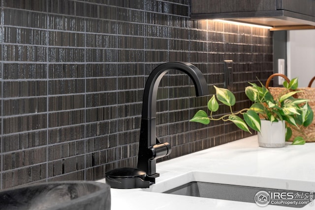 details featuring tasteful backsplash, light countertops, and a sink
