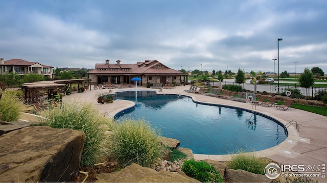 community pool featuring fence and a patio area