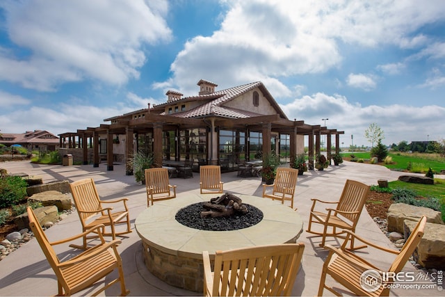 surrounding community featuring a fire pit, a pergola, and a patio