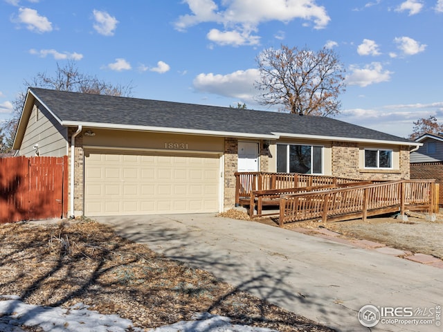 ranch-style home with a wooden deck and a garage