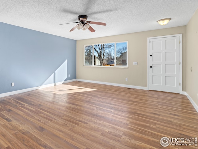 interior space featuring ceiling fan, hardwood / wood-style floors, and a textured ceiling