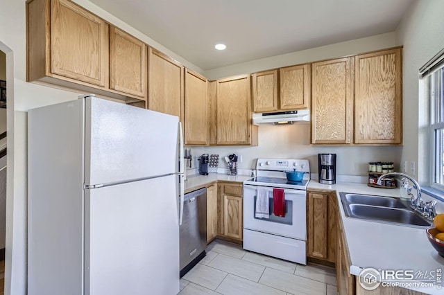 kitchen featuring light brown cabinetry, sink, white appliances, and light tile patterned floors