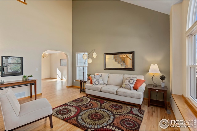 living room featuring light hardwood / wood-style floors and a high ceiling