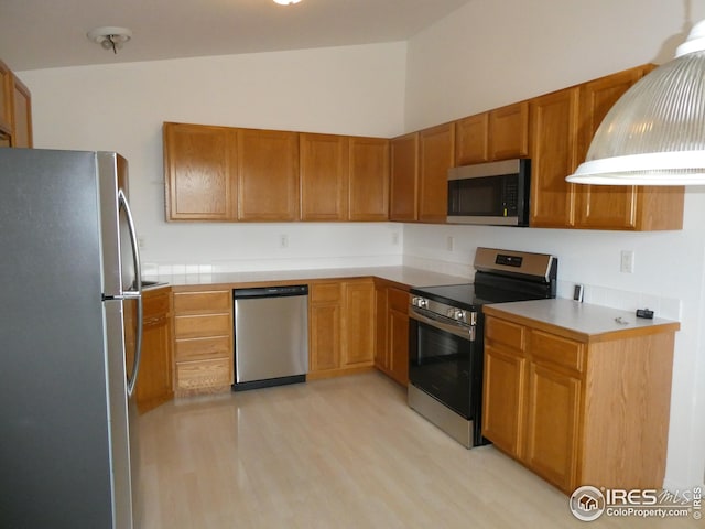 kitchen featuring vaulted ceiling, appliances with stainless steel finishes, and light hardwood / wood-style floors