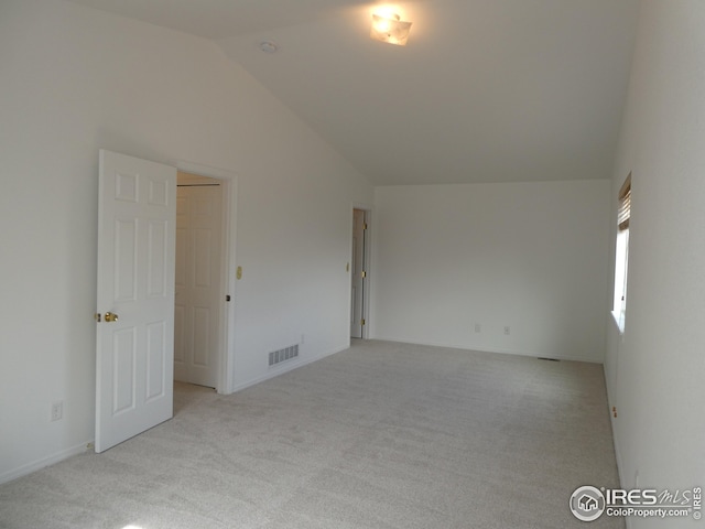 carpeted empty room featuring high vaulted ceiling