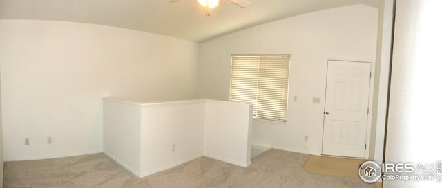 carpeted empty room with vaulted ceiling and ceiling fan