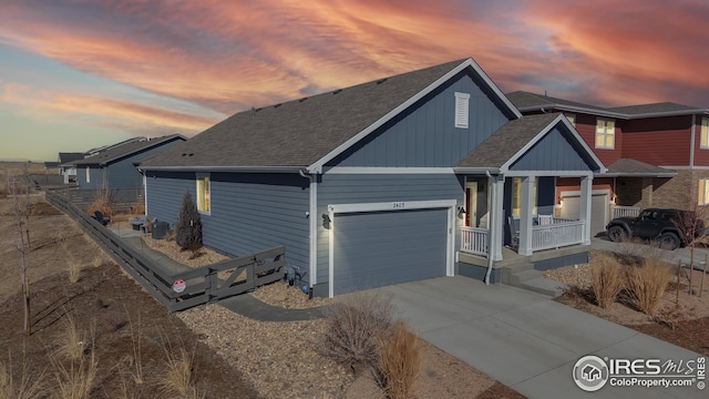 view of front facade featuring a porch, a shingled roof, driveway, and an attached garage