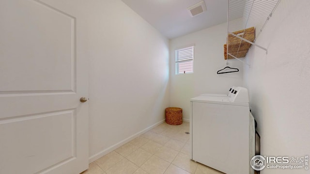 clothes washing area featuring visible vents, washing machine and clothes dryer, laundry area, and baseboards