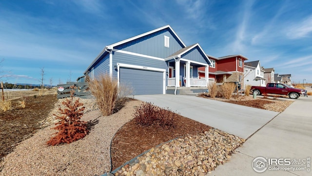 view of front of home with board and batten siding, an attached garage, covered porch, and concrete driveway