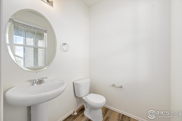 bathroom with hardwood / wood-style floors, sink, and toilet