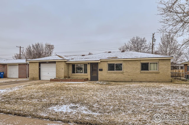 ranch-style home featuring a garage, brick siding, and fence